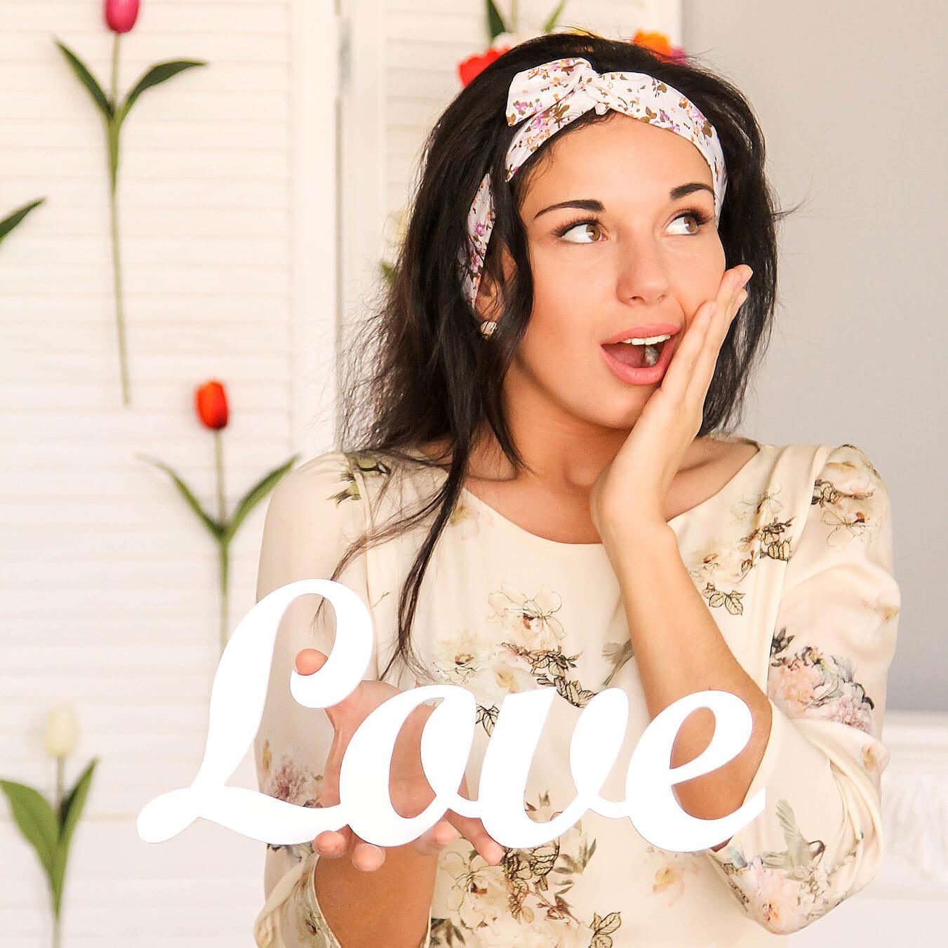 Woman with floral headband and love sign